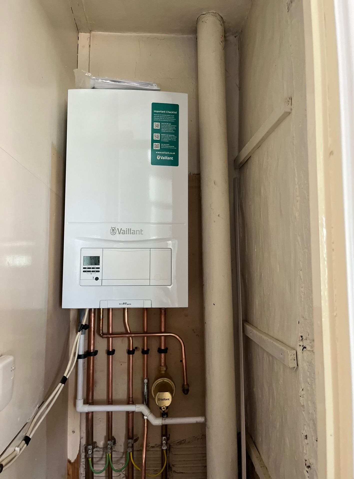 Wall-mounted combi boiler with neat copper pipework installed by a Gas Safe engineer